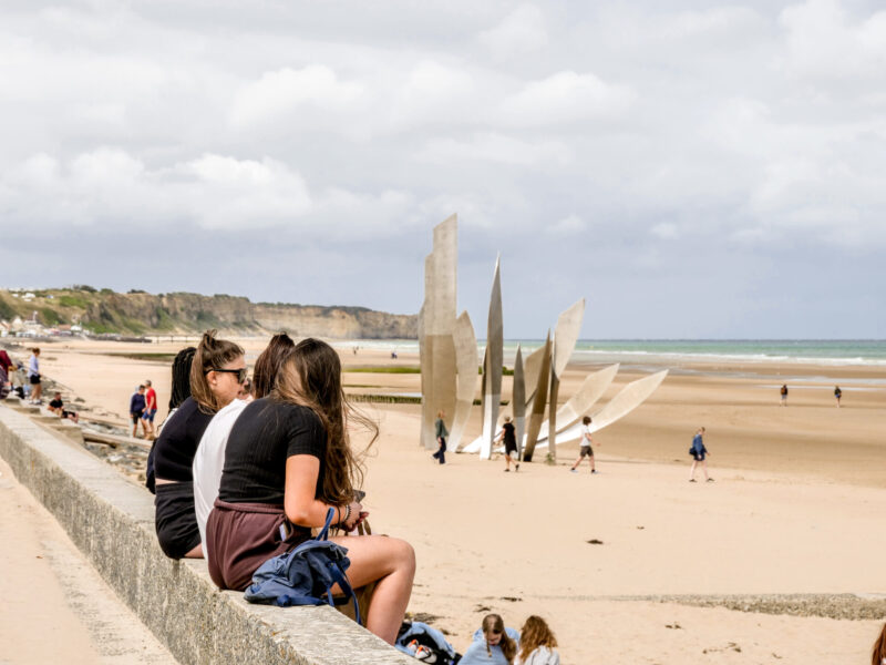 Students sitting on Omaha Beach in Normandy