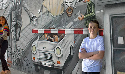 Student standing by the Berlin Wall