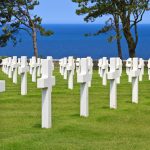 The peaceful American war cemetery near Omaha Beach with a blue sea and sky background