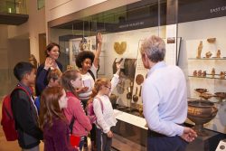 Students,Looking,At,Artifacts,In,Case,On,Trip,To,Museum