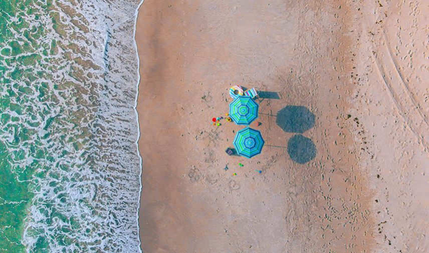 Aerial view of two blue umbrellas on a Florida beach