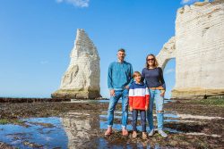 Happy,Family,Of,Three,People,Standing,On,The,Beach,In