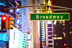 Broadway sign and red stop light in New York City at night