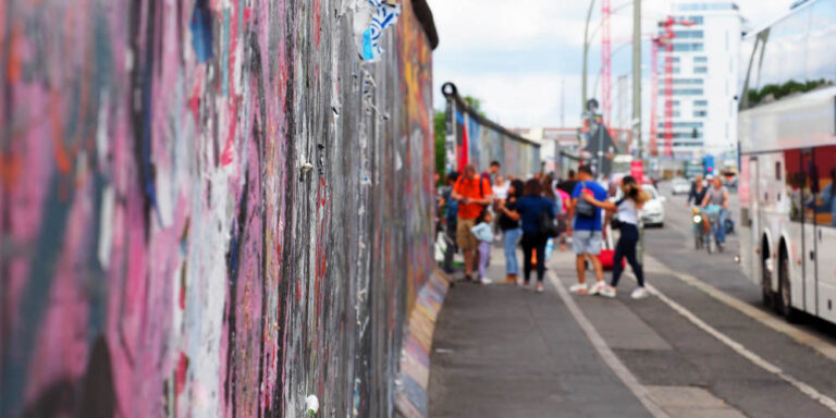 Group standing in front of the iconic Berlin Wall