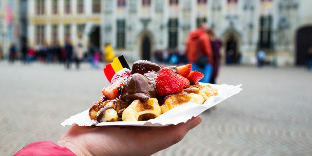 Belgian waffle covered in strawberries and chocolate sauce