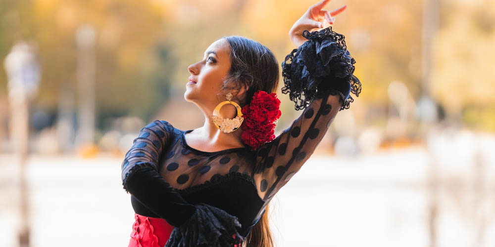 SPanish lady dancing flamenco in traditional black and red dress