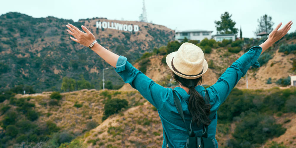 Girl looking at the iconic Hollywood sign in Los Angeles