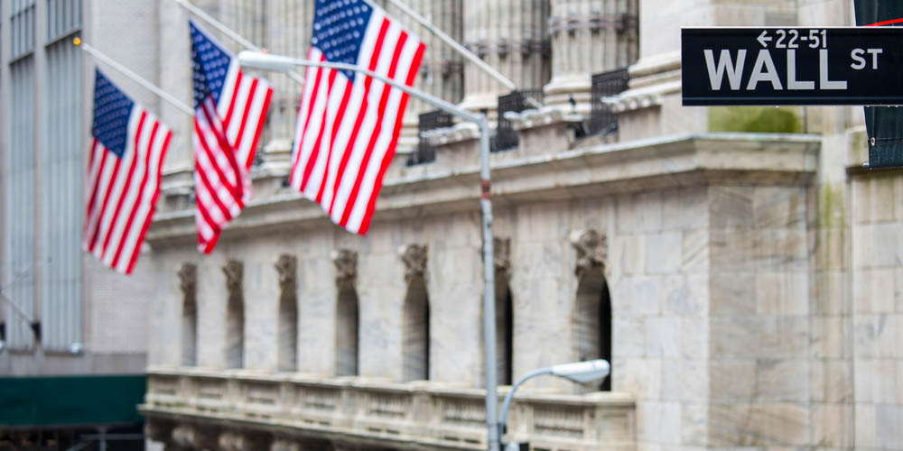 Wall street sign in New York with the New York Stock Exchange in the background
