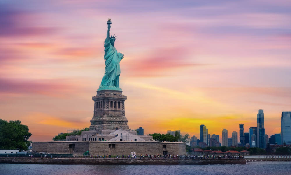 Statue of Liberty at sunset and Manhattan skyline, New York