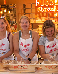 Students smiling at a pizza workshop at Grand Tour Italia