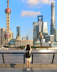 Student on the Shanghai Bund taking a picture of the iconic Shanghai skyline view of Lujiazui.