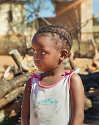 Little girl with braids in an African rural village