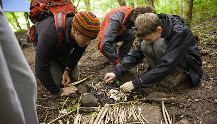 Children using survival methods in the woods
