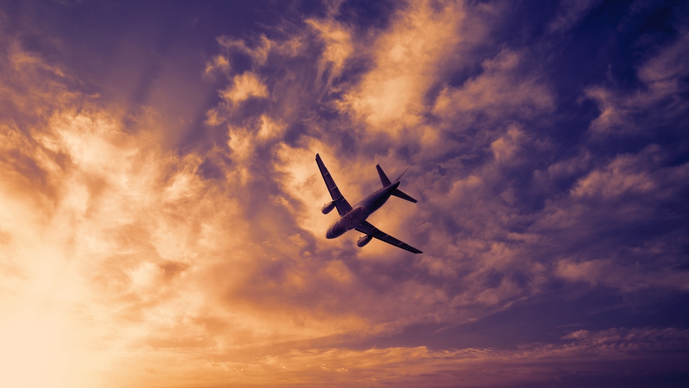 Plane flying in the sky at sunset