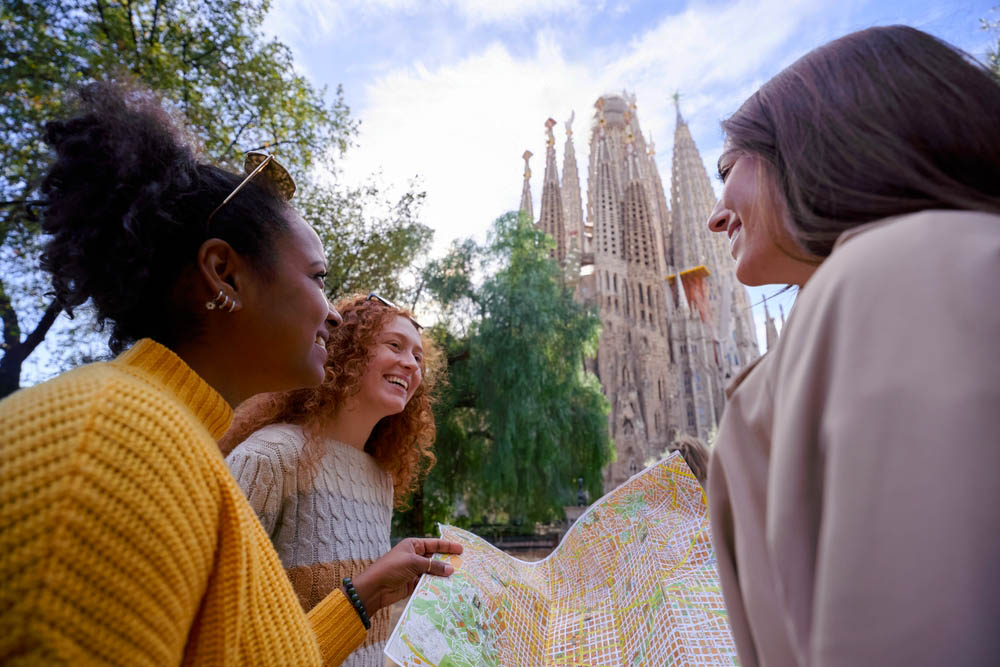 Three students looking at a map just outside the Sagrada Familia in Barcelona