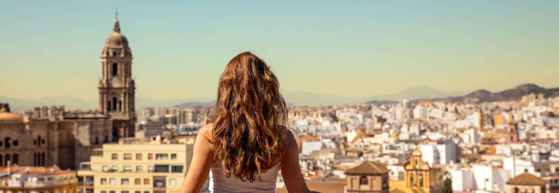 Panorama of a female student looking at Malaga city in Spain from a high viewpoint