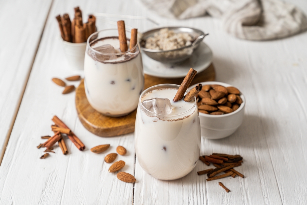 Horchata drinks with cinnamon sticks and almonds