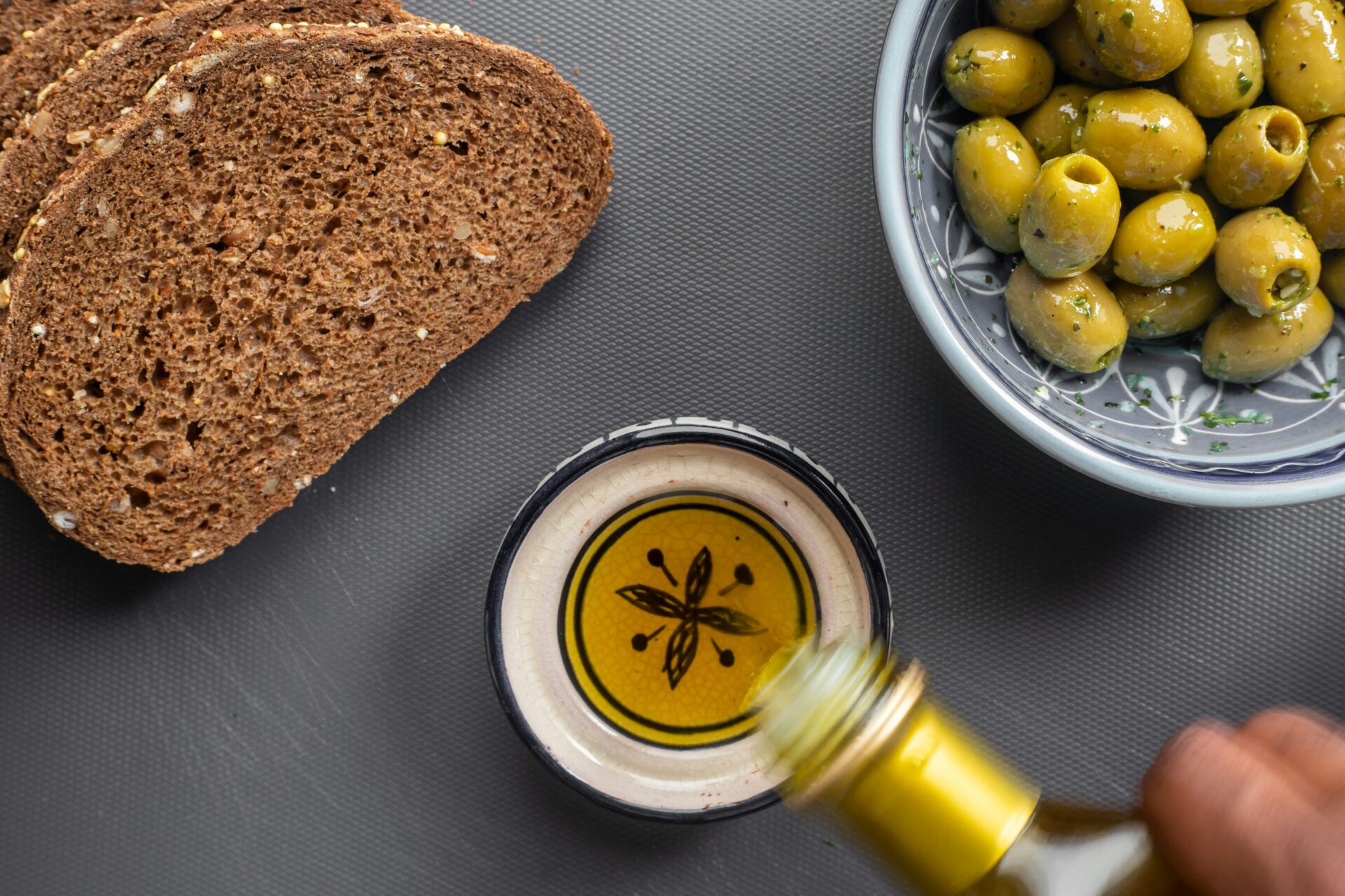 Olive oil in a bowl with olives and bread