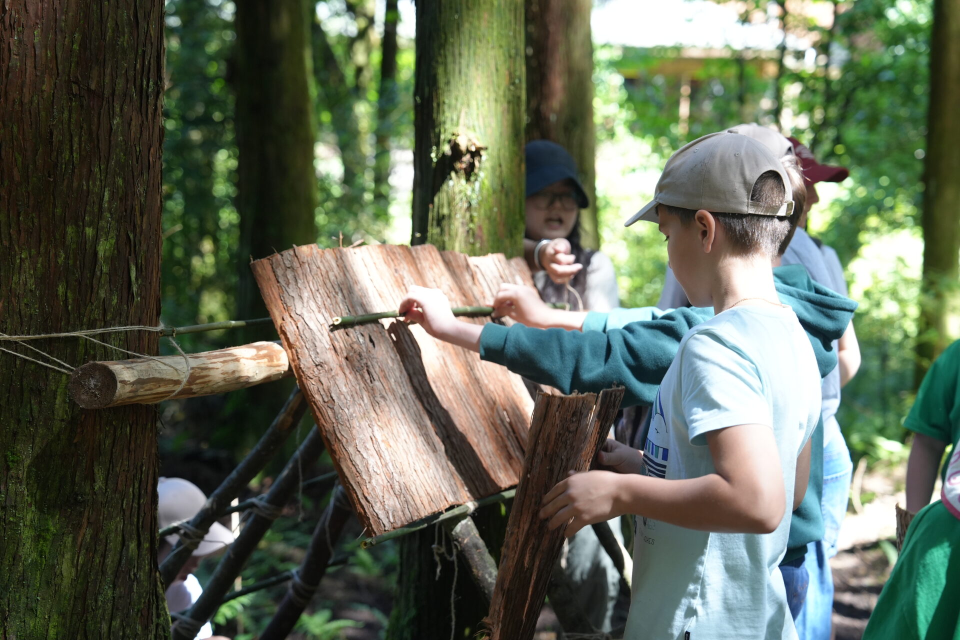 Young students examining a bamboo shelter for pandas in Chengdu
