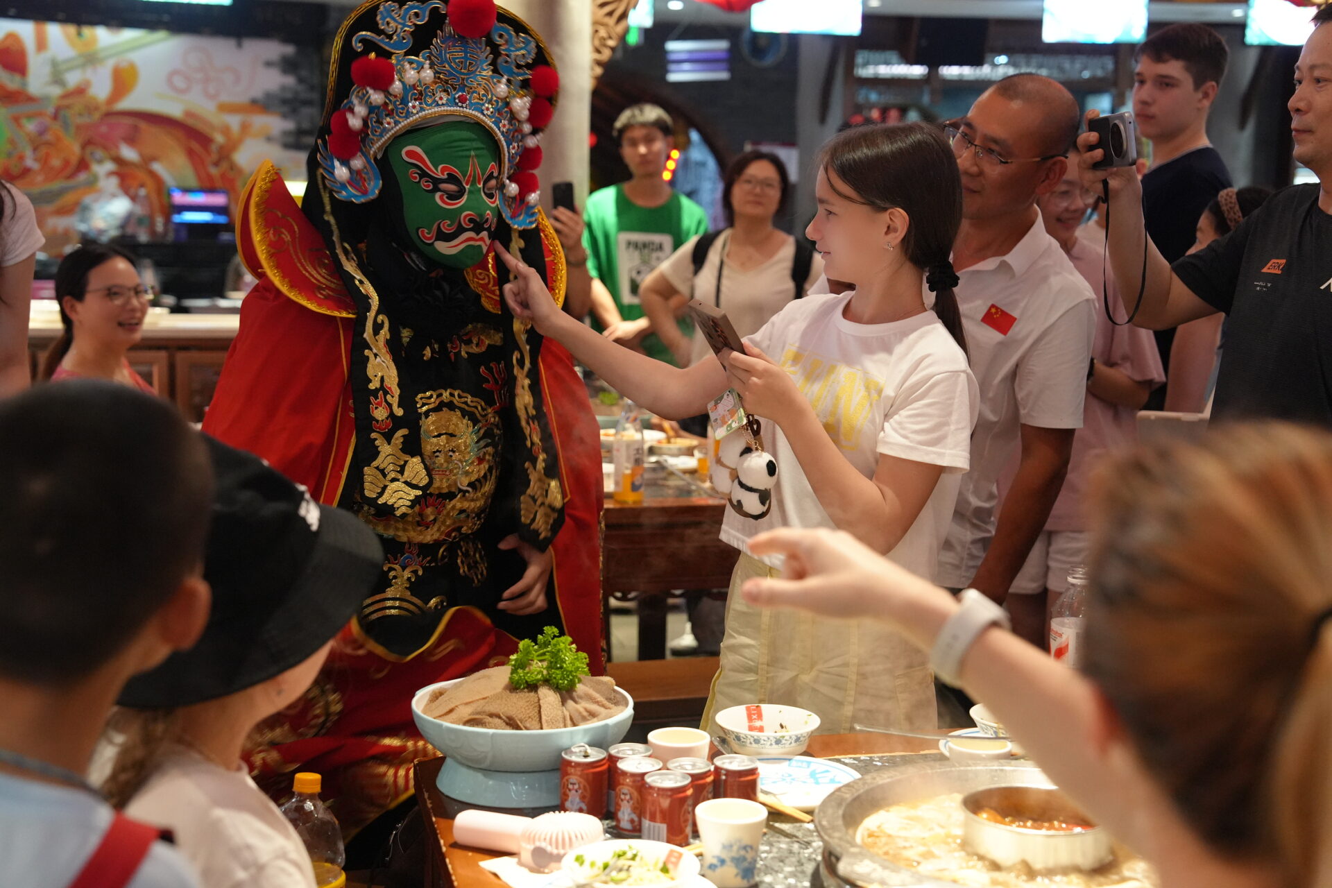 Group of students looking at a person dressed in traditional Chinese clothes during dinner in China