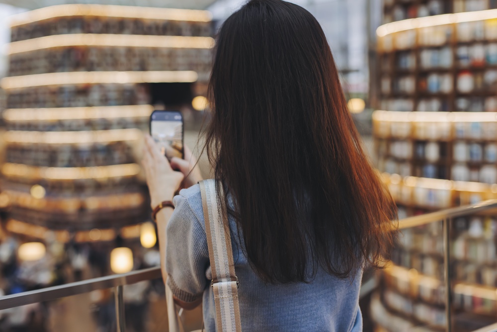 Student taking a photo at Starfield Library in COEX mall in Gangnam district, Seoul